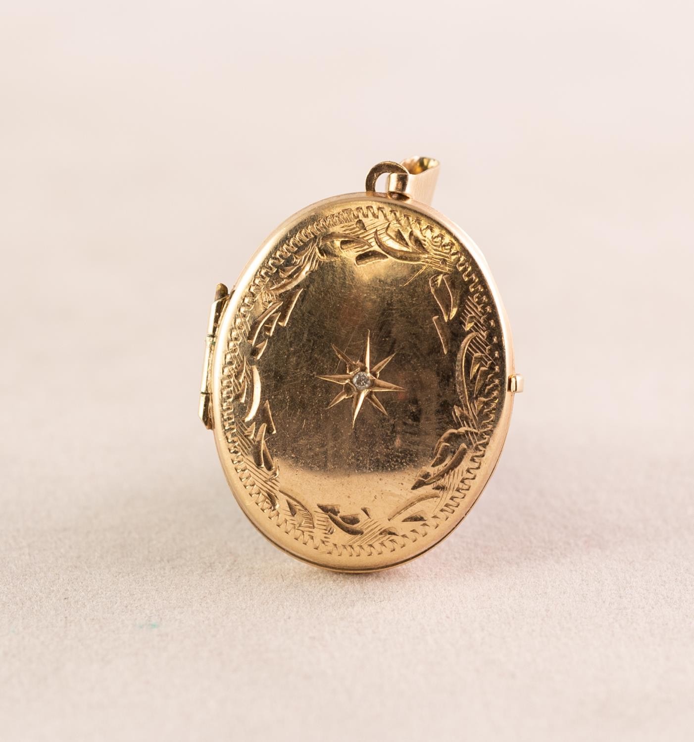 9ct GOLD SMALL ENGRAVED OVAL LOCKET PENDANT, star set with a tiny white stone, 1.9gms