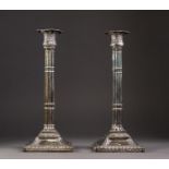 PAIR OF GEORGE III WEIGHTED SILVER CANDLESTICKS, the square bases with gadrooned borders and