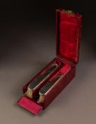 CASED PAIR OF PLAIN SILVER BACKED CLOTHES BRUSHES, each of slender form, housed in red lined and