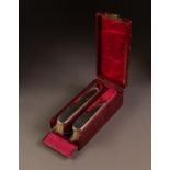 CASED PAIR OF PLAIN SILVER BACKED CLOTHES BRUSHES, each of slender form, housed in red lined and