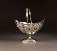 LATE VICTORIAN SWING HANDLED PEDESTAL SUGAR BASKET, of panelled oval form with reeded handle and