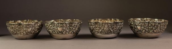 SET OF FOUR ORIENTAL EMBOSSED SILVER COLOURED METAL BOWLS, each of scalloped form, decorated with