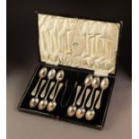 GEORGE V CASED SET OF TWELVE SILVER TEASPOONS AND MATCHING PAIR OF SUGAR TONGS, with bright cut