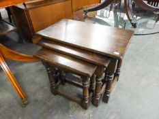 A NEST OF THREE JACOBEAN STYLE OAK OBLONG COFFEE TABLES, ON BALUSTER LEGS WITH PLAIN STRETCHER RAILS