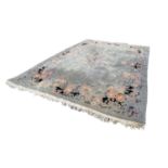 LARGE WASHED CHINESE CARPET, with a plain pale blue/grey field, embossed oval floral centre