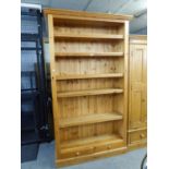 A GOOD QUALITY LARGE PINE OPEN BOOKCASE WITH FIVE ADJUSTABLE SHELVES AND TWO SMALL DRAWERS BELOW,