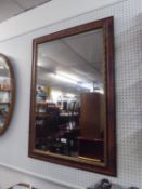 AN OBLONG WALL MIRROR IN WOODEN FRAME