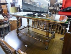 A DARK ELM LONG RECTANGULAR COFFEE TABLE, WITH TURNED LEGS AND STRETCHERS