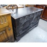 AN ANTIQUE PROFUSELY CARVED BLACK OAK CHEST WITH PLAIN LIFT UP TOP, ARCH CARVED TWO PANEL FRONT (3'