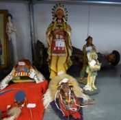 A RESIN STANDING FIGURE OF A COWBOY HOLDING A RIFLE, 20? HIGH (A.F.), TWO NATIVE AMERICAN WALL MASKS