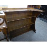 AN OAK OPEN BOOKCASE WITH SHAPED TOP