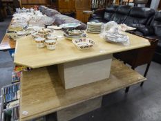 A CREAM MARBLE OBLONG COFFEE TABLE WITH CANTED CORNERS ON SQUARE BLOCK BASE