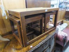 A TEAK OBLONG COFFEE TABLE ON CONTINUOUS SUPPORTS WITH A PAIR OF NESTING COFFEE TABLES