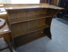 AN OAK OPEN BOOKCASE WITH SHAPED TOP