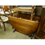 AN OAK OVAL GATE LEG DINING TABLE, ON TWO TRESTLE SUPPORTS WITH SLEDGE FEET, THE PLAIN GATE LEGS