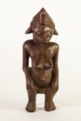 AFRICAN CARVED SOFTWOOD MODEL OF A NUDE FEMALE FIGURE, seated on a stool, 15" (38.1cm) high (a.f.)