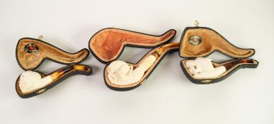 THREE MODERN SERVI-MEERSHAUM SMOKING PIPES IN CASES, one carved as a claw holding a skull, (used),