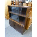 AN OAK THREE-TIER SECTIONAL BOOKCASE, THE TWO UPPER SECTIONS WITH GLASS SLIDING DOORS, THE BOTTOM
