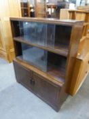 AN OAK THREE-TIER SECTIONAL BOOKCASE, THE TWO UPPER SECTIONS WITH GLASS SLIDING DOORS, THE BOTTOM