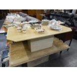 A CREAM MARBLE OBLONG COFFEE TABLE WITH CANTED CORNERS ON SQUARE BLOCK BASE