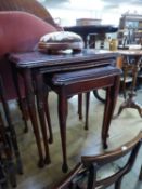 A NEST OF THREE REPRODUCTION MAHOGANY COFFEE TABLES WITH GLASS INSET TOPS AND A SMALL CIRCULAR STOOL