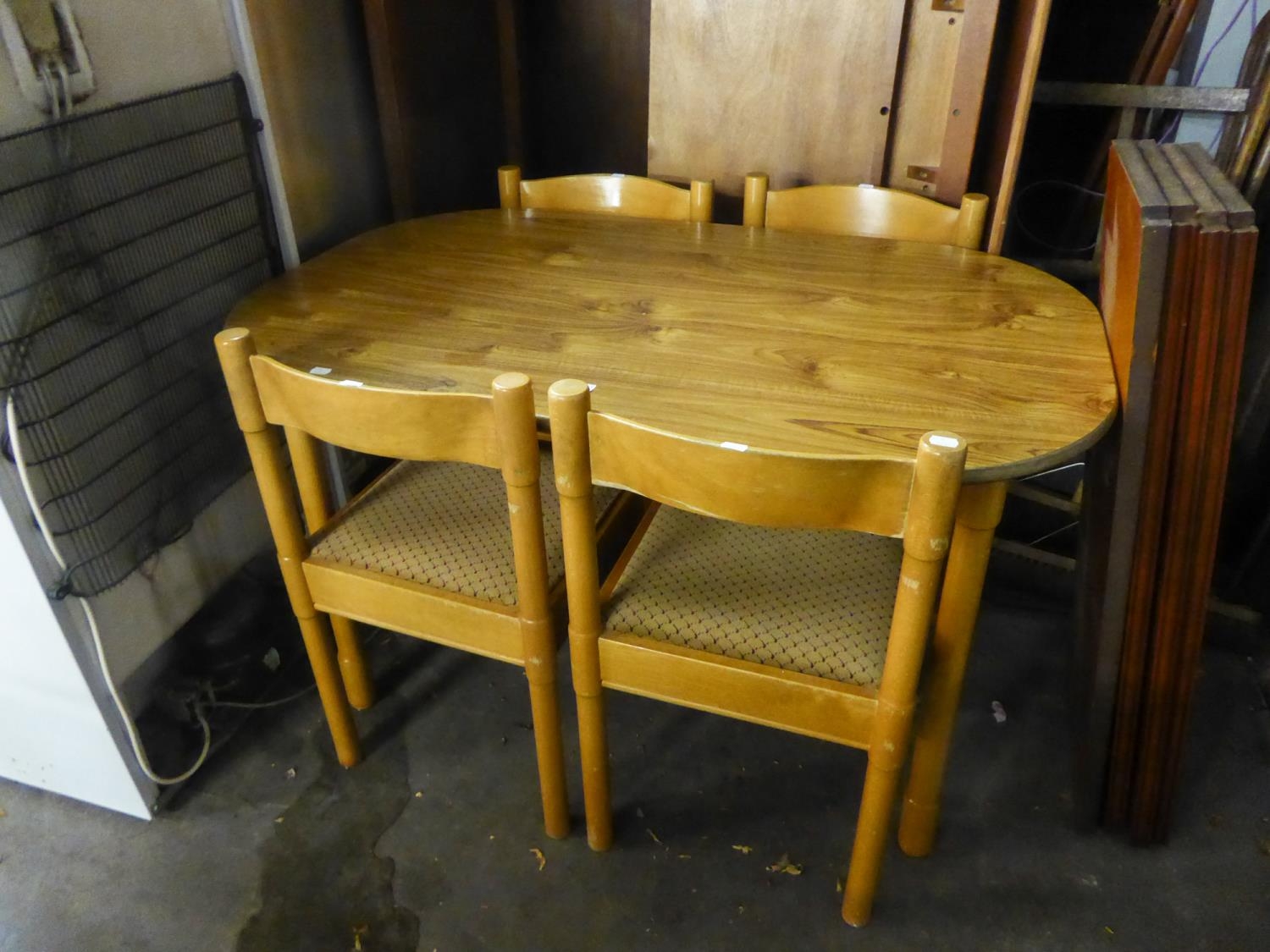 A WOOD EFFECT KITCHEN TABLE, ON FOUR BEECH POST SUPPORTS AND A SET OF FOUR BEECH WOOD DINING