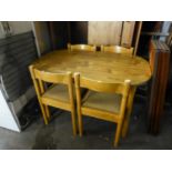 A WOOD EFFECT KITCHEN TABLE, ON FOUR BEECH POST SUPPORTS AND A SET OF FOUR BEECH WOOD DINING