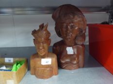 A CARVED WOODEN BUST OF A SEMI-NUDE WOMAN AND A SMALLER SIMILAR BUST OF A MAN, BOTH STAMPED 'BALI'