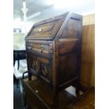 AN OAK BUREAU WITH SLOPING FALL FRONT, DRAWER AND CUPBOARD BELOW