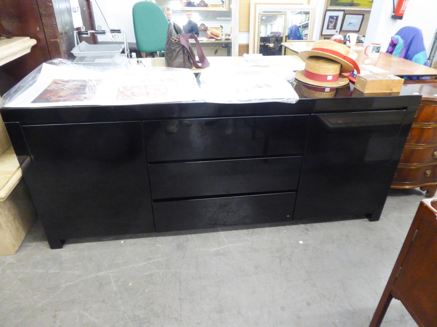 A BLACK GLOSS 'NEWTON' SIDEBOARD WITH THREE CENTRAL DRAWERS, FLANKED BY TWO END CUPBOARDS, ON PLINTH