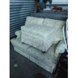 PARKER KNOLL TWO SEATER SETTEE AND MATCHING LARGE RECTANGULAR FOOTSTOOL, COVERED IN GOLD ON WHITE