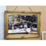 A GOOD QUALITY GILT FRAMED BEVELLED EDGE WALL MIRROR WITH MOULDED DECORATION (FRAME 110cm x 80cm)