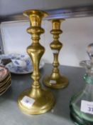 A PAIR OF ANTIQUE BRASS BALUSTER CANDLESTICKS, ON CIRCULAR BASES, WITH EJECTORS