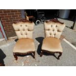 A PAIR OF REPRODUCTION LOW NURSING CHAIRS COVERED IN CREAM FABRIC  (2)