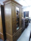 A WAXED PINE SINGLE WARDROBE WITH BEVELLED MIRROR DOOR AND A PINE BEDSIDE CABINET (2)