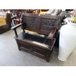 AN INTER-WAR YEARS OAK MONKS BENCH, WITH LINEN-FOLD PANELS TO THE BOX BASE