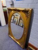 LARGE OVAL BEVELLED EDGE WALL MIRROR, IN RECTANGULAR GILT FRAME, WITH ROCOCO EMBOSSED CORNERS