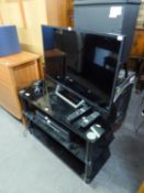 SONY FLAT SCREEN TELEVISION, 31? ON A THREE TIER BLACK GLASS STAND AND A PHILIP VIDEO CASSETTE