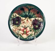 MODERN MOORCROFT TUBE LINED POTTERY PLATE, painted in colours and decorated with three flowers, on a