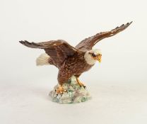 BEWICK POTTERY FIGURE OF A BALD EAGLE, wings displayed, on a rocky outcrop, impressed marks and