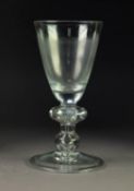 LARGE BALUSTER GLASS GOBLET, with funnel bowl, above a shoulder knop and baluster knop to the