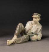 ROYAL COPENHAGEN CHINA FIGURE, painted in muted tones and modelled as a reclining man eating, (865),