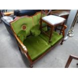 A VICTORIAN TWO SEATER MAHOGANY FRAMED SETTEE, COVERED IN GREEN FABRIC WITH TWO CIRCULAR CARVINGS TO