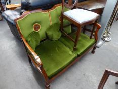 A VICTORIAN TWO SEATER MAHOGANY FRAMED SETTEE, COVERED IN GREEN FABRIC WITH TWO CIRCULAR CARVINGS TO