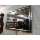 AN OBLONG BEVELLED EDGE WALL MIRROR WITH SILVERED FRAME