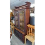 A POSSIBLY WALNUT TWO GLASS PANELLED DOOR DISPLAY CABINET, ABOVE A FALL-FRONT ENCLOSED CUPBOARD