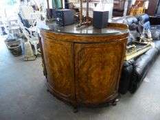 A 1930's FIGURED WALNUT DEMI LUNE SIDE CABINET