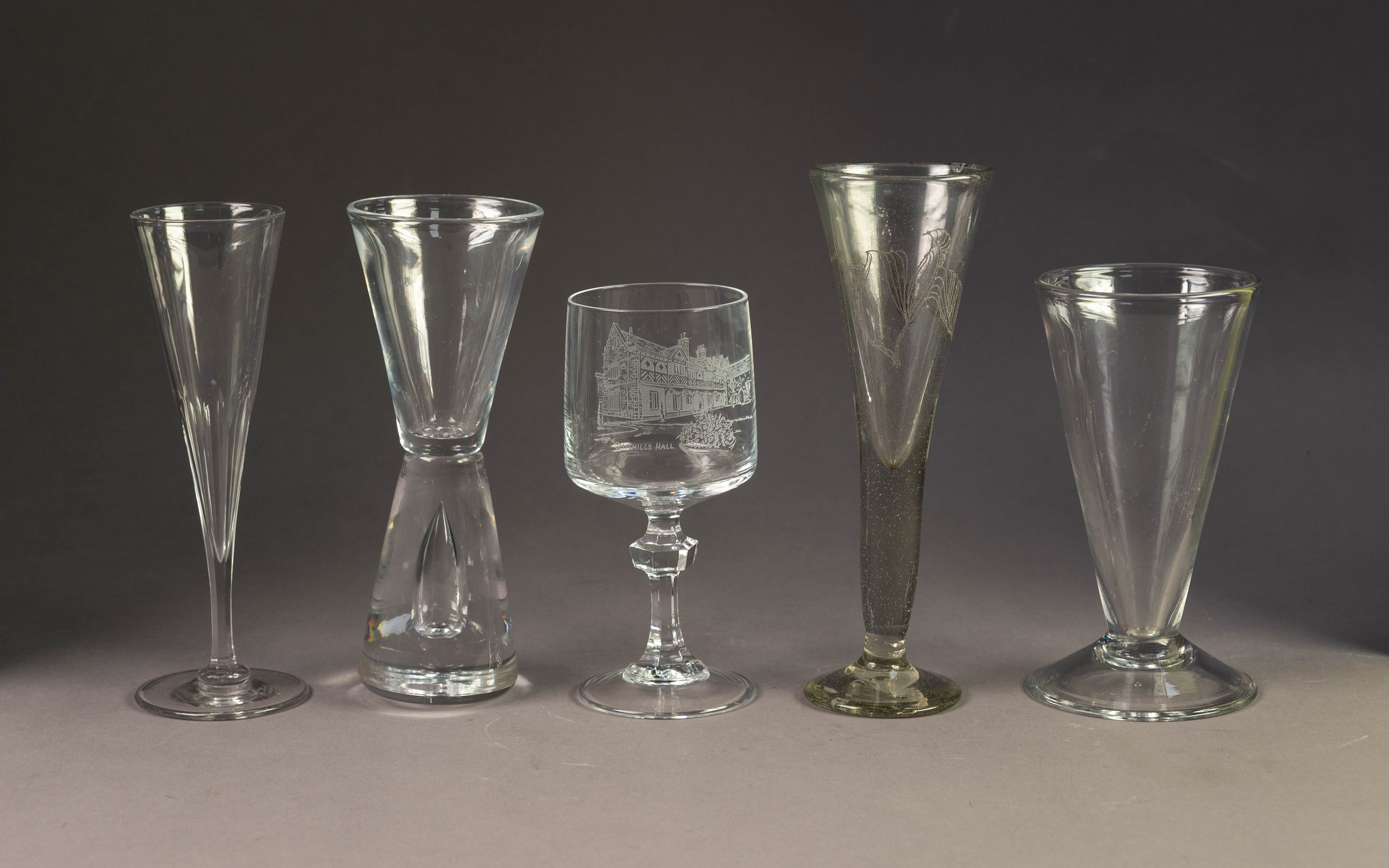 FIVE ANTIQUE AND LATER DRINKING GLASSES, including one of conical form with tear shaped inclusion to