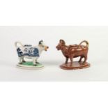 NINETEENTH CENTURY BLUE AND WHITE POTTERY COW CREAMER, on rounded oblong base, together with a BROWN