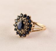 9K GOLD CLUSTER RING set with a centre oval sapphire, surround of tiny white stones and outer